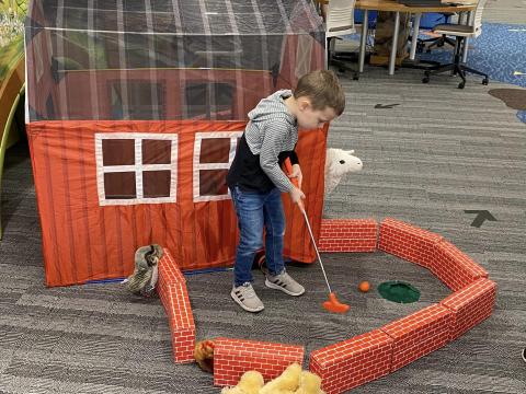 Child Putt Putting in the Library